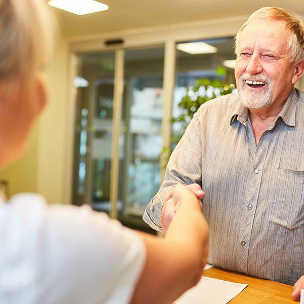 Man shaking hands with dental receptionist